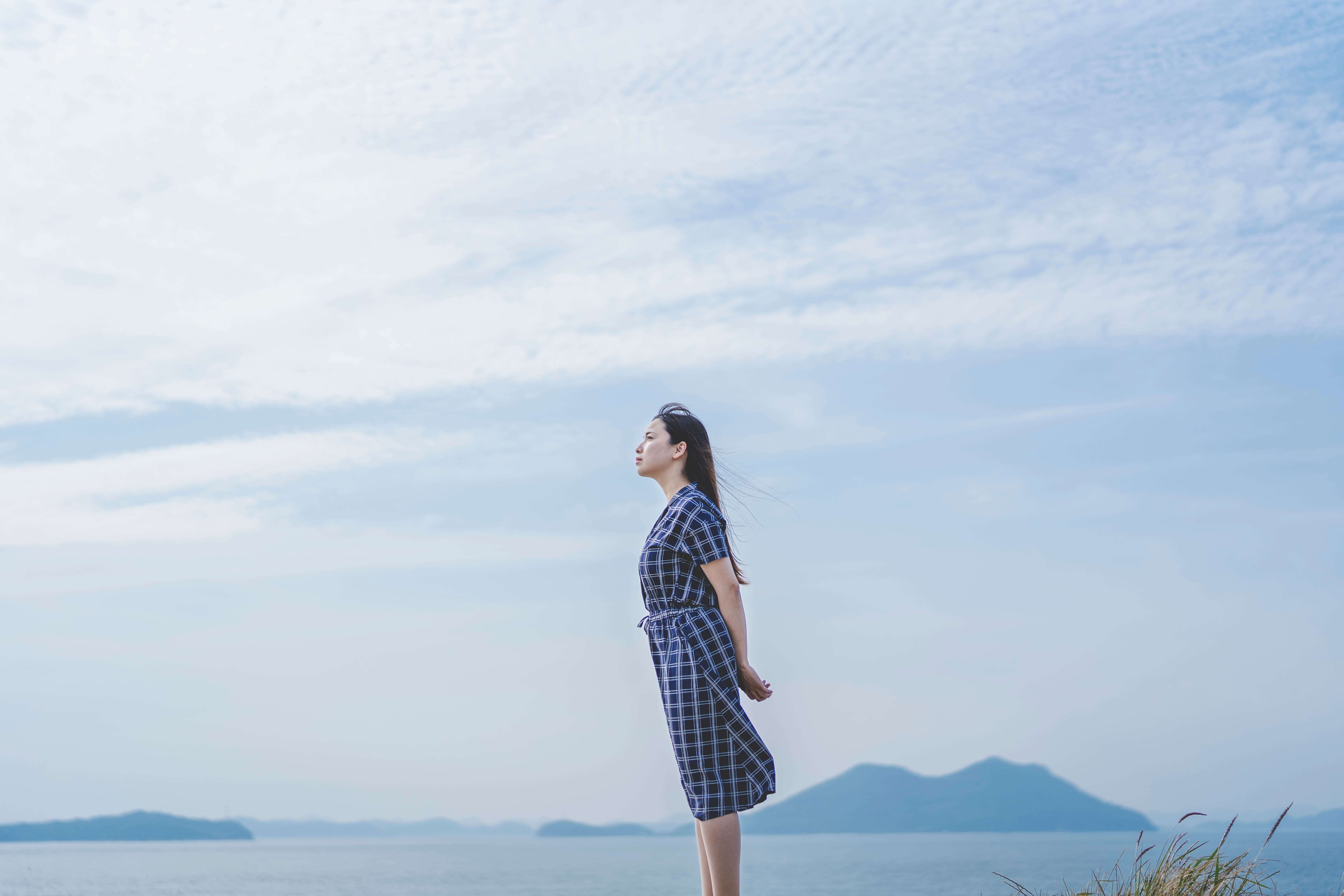 脳疲労を考えている海のそばで遠くを見つめている女性
