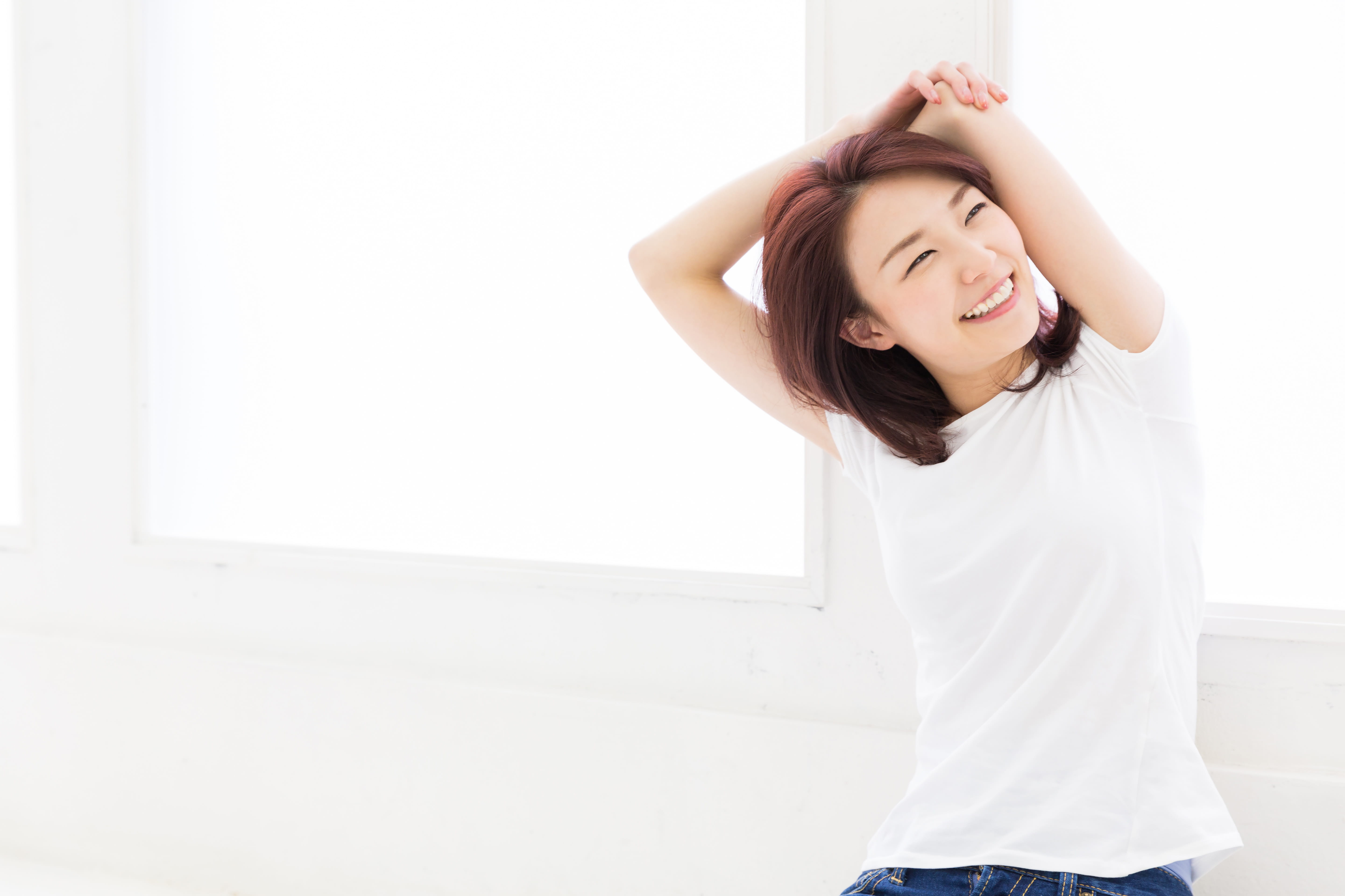 脳疲労を感じさせない部屋でストレッチをしている女性